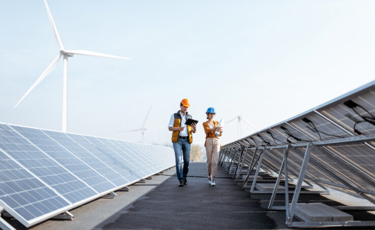 two energy workers walking through a solar farm